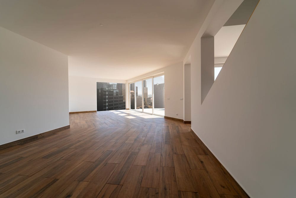 Empty room with dark wooden floating laminate flooring. House in Houten vloeren Lisse